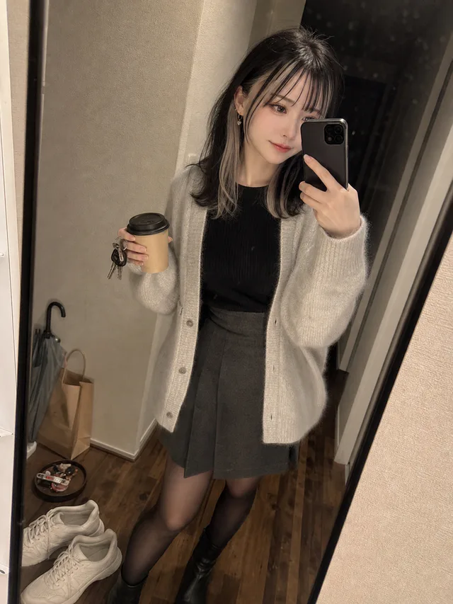 深夜のワンルーム玄関で、黒とアッシュブロンドの髪の成人女性がカップと鍵を持って鏡越しに自撮りするAI生成写真