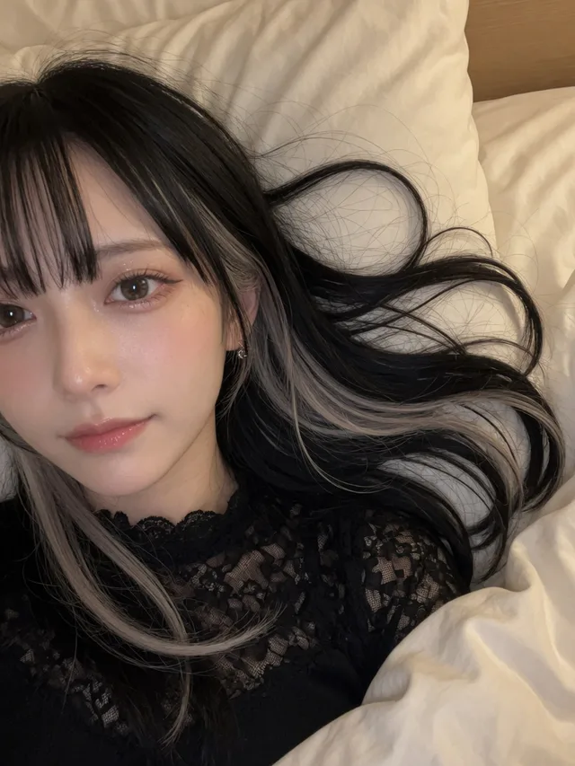 白いベッドで超近距離自撮りする黒銀ハイライト髪の日本人女性